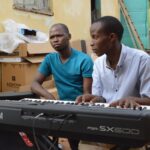 Deputy Prime Minister Thulisile Dladla hands over musical instruments to Nkosenomusa Sibaya Gamedze, a visually impaired musician, in a gesture of support for his musical career.