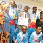 Minister Bongani Nzima presents cash rewards to Eswatini medalists for their international victories.