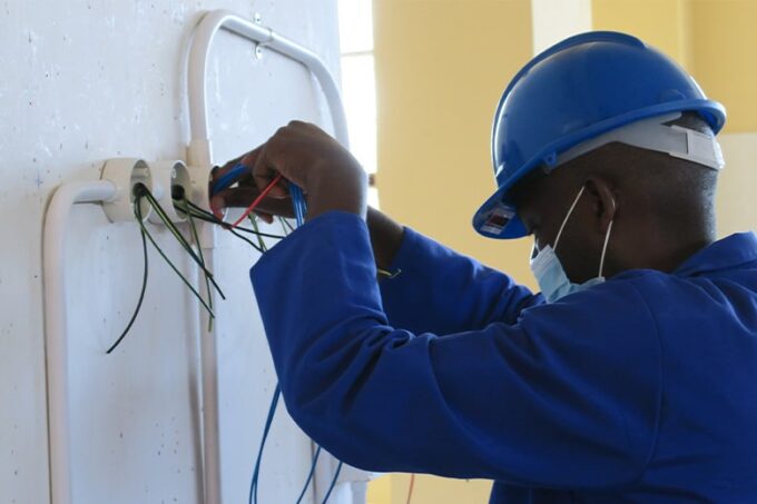 An electrician carefully installing wiring during a job on-site