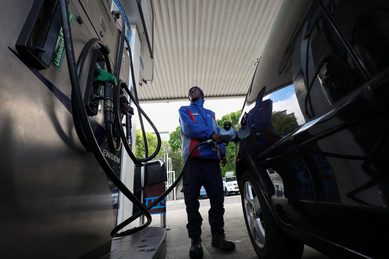 A worker fills a car at a petrol station in Cape Town, South Africa, March 25, 2026. REUTERS/Esa Alexander