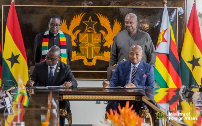 Presidents John Dramani Mahama of Ghana and Emmerson D. Mnangagwa of Zimbabwe stand behind their respective Foreign Affairs Ministers during the signing ceremony in Accra.