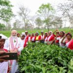 PM Narendra Modi interacts with women workers at a tea garden in Dibrugarh, Assam, taking a selfie during his visit.
