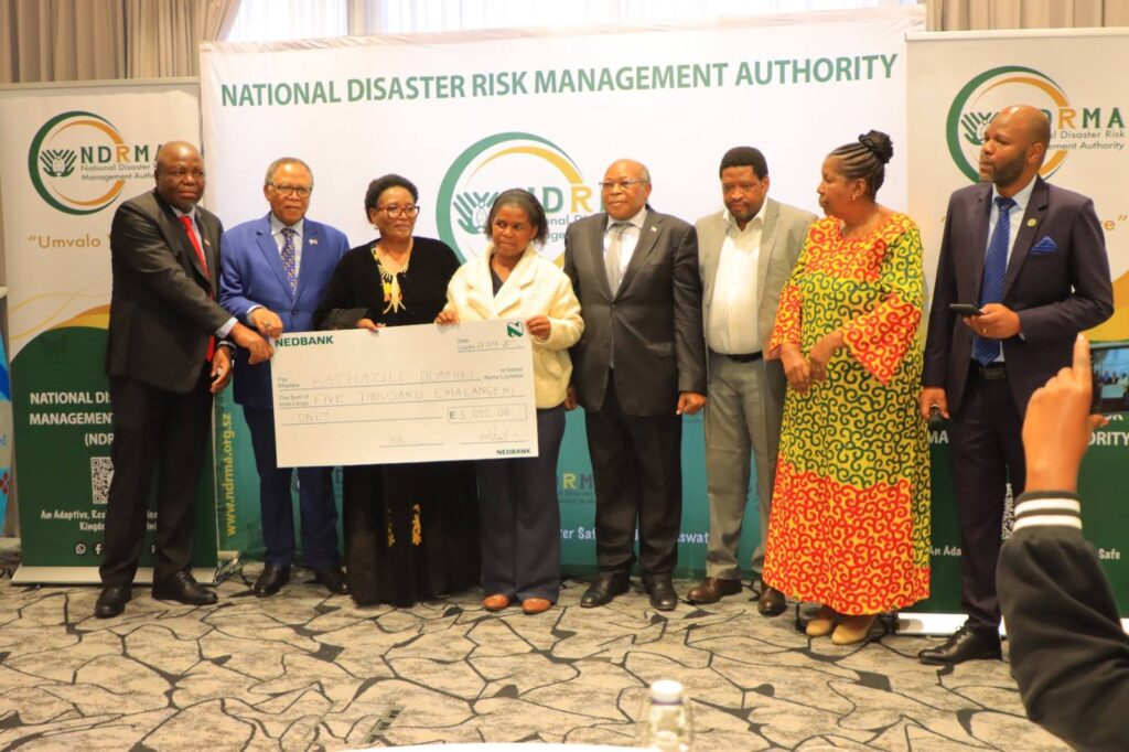 Deputy Prime Minister Thulisile Dladla presents a cheque of E5,000 to Bachazile Dlamini at the launch of Umvalo Wesive, after she jointly won the siSwati naming competition for coining the name of the Kingdom's new National Disaster Risk Management Authority.