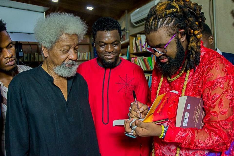 Nigerian author and filmmaker Onyeka Nwelue signs a copy of his book "The Beginning of Everything Colorful" for Nobel Laureate Wole Soyinka,
