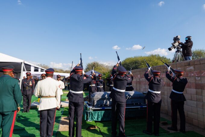 Soldiers fire a salute as the coffin of former Botswana President Festus Gontebanye Mogae is lowered to rest at Phomolong Cemetery in Gaborone during a state burial conducted with full military honours.