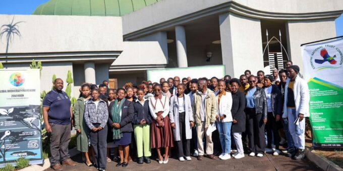 ENTC Chief Executive Officer Thulani Methula, Acting Principal Secretary for the Ministry of Tourism and Environmental Affairs Dudu Nhlengethwa-Masina, and youth participants pose for a group photo at the Youth Engagement Workshop held at King Sobhuza Memorial Park