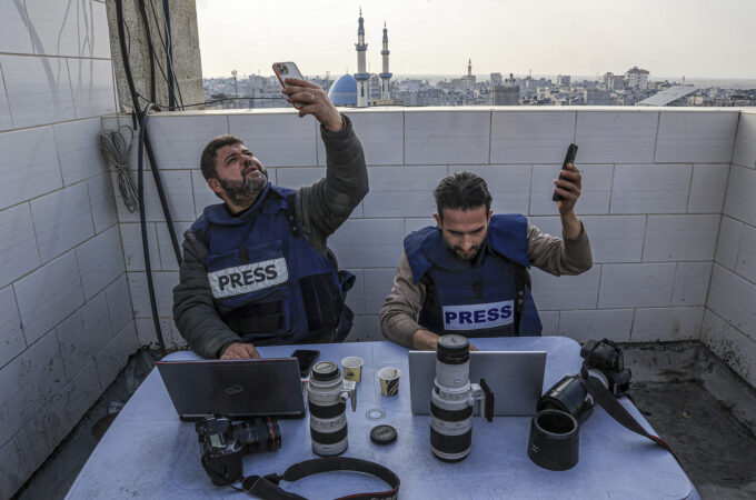 Palestinian journalists attempt to connect to the internet using their phones in Rafah on the southern Gaza Strip on December 27, 2023. Said Khatib / AFP