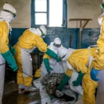 Disinfecting the body of Bahati Ibiliabo, 22, from Mongbwalu, who had gone to the hospital one day before he died. Photo by The New York Times
