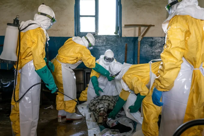 Disinfecting the body of Bahati Ibiliabo, 22, from Mongbwalu, who had gone to the hospital one day before he died. Photo by The New York Times